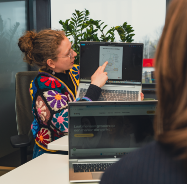 Vrouw laat iets zien op een laptop.